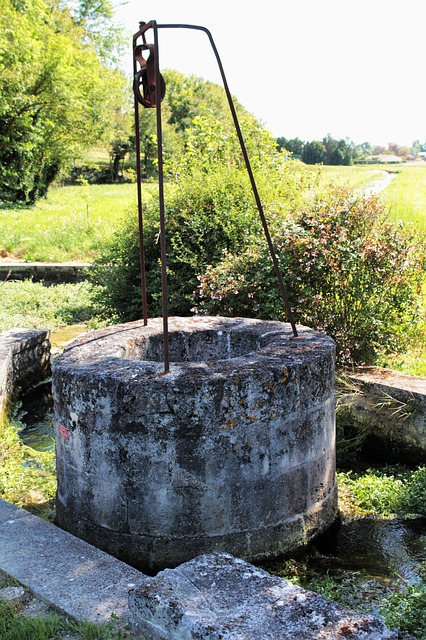 Stone well in green field